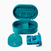 The Effy Oval Travel Case is a small, oval-shaped zippered case in teal vegan leather with a matching teal zipper, closed and displayed on a white background.