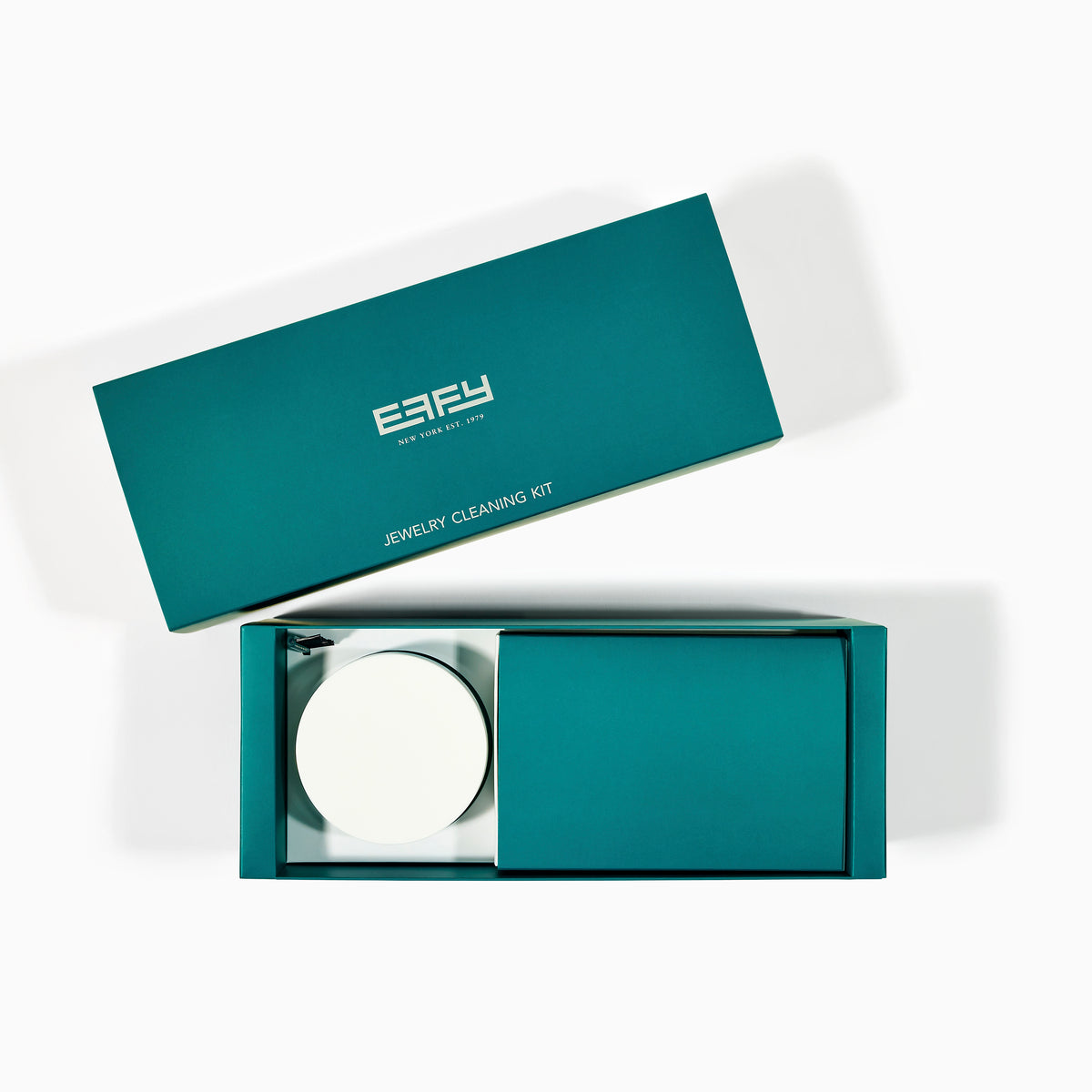 The Jewelry Cleaning Kit, featuring a Crystal Repair Cleanser jar, dual-ended brush, pen-style Jewelry Cleaner, and gray EEFY Polishing Cloth, is neatly displayed on a white background for Sparkle + Shine.