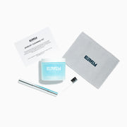The Jewelry Cleaning Kit, featuring a Crystal Repair Cleanser jar, dual-ended brush, pen-style Jewelry Cleaner, and gray EEFY Polishing Cloth, is neatly displayed on a white background for Sparkle + Shine.