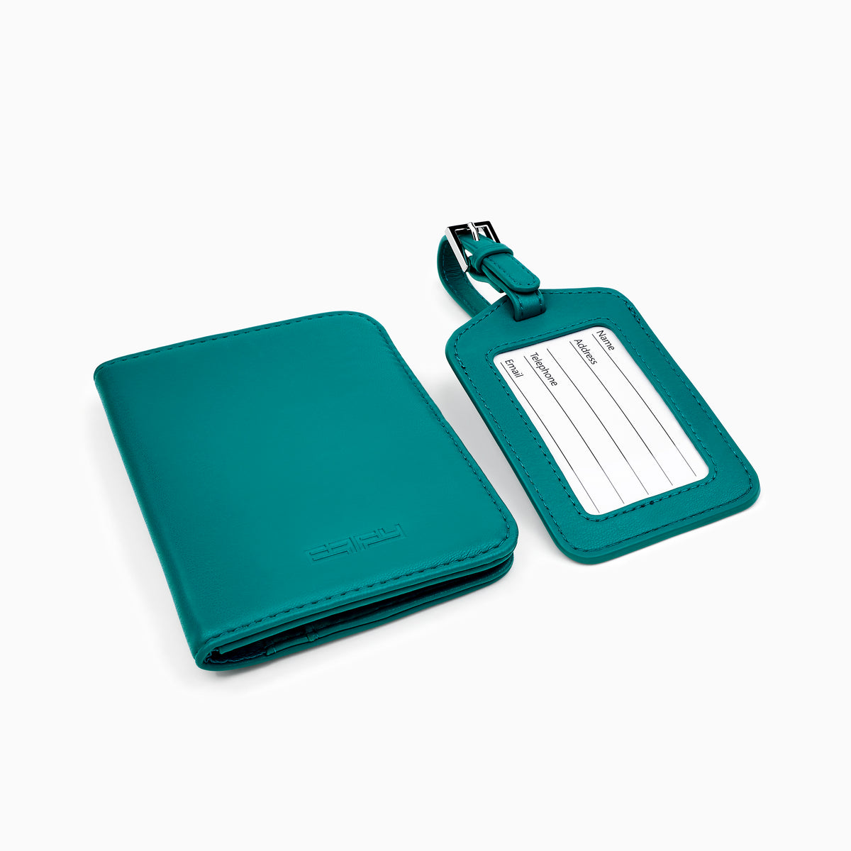An open teal gift box showcases the Effy Passport Holder and Luggage Tag Travel Set, including a matching vegan leather passport holder, luggage tag, and pen, each neatly arranged in fitted compartments against a white background.