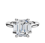 A platinum engagement ring named "Platinum 3-Stone Baguette Side Stones Set North/South 0.125TCW" features a center stone flanked by baguette side stones, set on an elegant polished band against a white background.