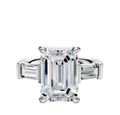 The 18K White Gold 3-Stone Baguette East/West Side Stones 0.25TCW Engagement Ring features a central stone flanked by two baguette-cut diamonds, beautifully set against a white background.