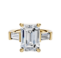 The 18K Yellow Gold 3-Stone Baguette East/West Side Stones 0.25TCW Engagement Ring features a central diamond and two rectangular baguette side stones, displayed against a plain white background.