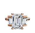 The 18K Rose Gold 3-Stone Baguette Side Stones Set North/South 0.25TCW Engagement Ring features a central diamond with two baguette side stones in a classic prong setting, displayed against a plain white background.