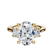 The 14K Yellow Gold 3-Stone Oval Side Stones 0.125TCW Engagement Ring features a large oval center diamond and two smaller round diamonds on each side, shown against a plain white background.
