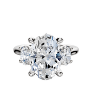 The 14K White Gold 3-Stone Oval Side Stones 0.25TCW Engagement Ring features a large oval diamond between two smaller round stones in a classic four-prong setting, displayed on a plain white background.