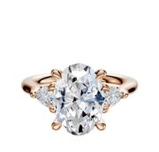 The 18K Rose Gold 3-Stone Engagement Ring features a central diamond accented by pear-shaped side stones totaling 0.125 carats, set in a sleek, polished band.