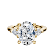 An 18K Yellow Gold 3-Stone Engagement Ring with a center diamond and two pear-shaped side stones (0.125TCW), displayed on a plain white background.