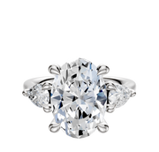 A 14K white gold engagement ring with a three-stone design showcases a center stone accented by two pear-shaped side stones (0.25TCW), displayed against a plain white background.