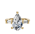 The 14K Yellow Gold 3-Stone Baguette East/West Side Stones 0.125TCW Engagement Ring features a central pear-shaped diamond with two baguette-cut side diamonds, shown against a plain white background.