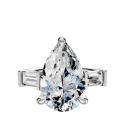 An 18K White Gold 3-Stone Engagement Ring featuring a faceted center stone and two east/west baguette side stones (0.25 TCW), shown on a polished white band against a plain white background.