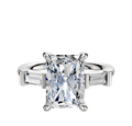 A 14K white gold engagement ring featuring three stones: a center stone flanked by east/west baguette side stones, totaling 0.125TCW, set on a polished band against a white background.