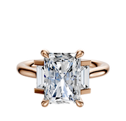 The 18K Rose Gold 3-Stone Baguette Side Stones Set North/South 0.125TCW Ring features a central diamond accented by two rectangular baguette side stones, set on a polished rose gold band against a plain white background.