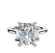The Platinum 3-Stone Baguette Side Stones Set North/South 0.125TCW Ring features a central diamond flanked by two baguette side stones, all set on a simple, polished platinum band.