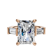 A 14K rose gold engagement ring featuring a large center baguette gemstone held by four prongs, flanked by two horizontally set baguette side stones for a total carat weight of 0.25.