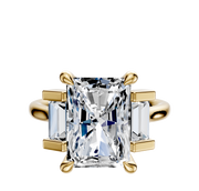 The 14K Yellow Gold 3-Stone Baguette Side Stones North/South Engagement Ring features a radiant center stone with two rectangular baguette side gems, all set in a polished gold band and totaling 0.25TCW.