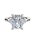An 18K white gold engagement ring with a large center stone and two trillion-cut side stones (0.125TCW), showcased against a plain white background.