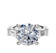 The Platinum 3-Stone Baguette East/West Side Stones 0.25TCW Engagement Ring features a round center diamond with two rectangular baguette side stones, shown on a plain white background.