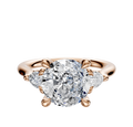 The 14K Rose Gold 3-Stone Engagement Ring features a center diamond with two pear side stones, totaling 0.125 TCW, set in a classic setting against a simple background.