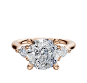 The 14K Rose Gold 3-Stone Engagement Ring features a center diamond with two pear side stones, totaling 0.125 TCW, set in a classic setting against a simple background.