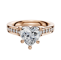The 14K Rose Gold 4 Prong Basket Cathedral Flat 1-Row-Pave 2.5mm Engagement Ring features a heart-shaped diamond center and small round diamonds set along the band.