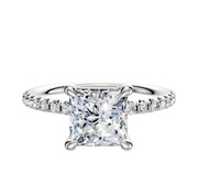 A 14K white gold engagement ring with a 4-prong basket setting, classic dome design, and a 2.5mm band accented by a single row of pave-set diamonds.