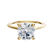 A 14K yellow gold cathedral knife edge engagement ring, featuring a 1.5mm band and round diamond set in four prongs with a hidden halo, displayed on a plain light background.