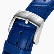 The 38MM Swiss Made Stainless Steel Spinning Starfish Watch features diamonds, blue topaz, a blue leather strap, silver face with blue accents, silver hands, the EARY logo on the dial, and a jeweled starfish motif near the bottom.