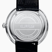 The 39MM Swiss Made Stainless Steel Watch with Diamonds showcases a round diamond-encrusted bezel, mother-of-pearl dial with silver numerals, and a black leather strap, elegantly set against a plain white background.