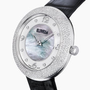 The 39MM Swiss Made Stainless Steel Watch with Diamonds showcases a round diamond-encrusted bezel, mother-of-pearl dial with silver numerals, and a black leather strap, elegantly set against a plain white background.