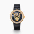 The 39MM Swiss Made 18K Yellow Gold Signature Round Panther Watch with Diamonds features a jeweled panther face on a glossy black dial, green eyes, gold hands, and a diamond-encrusted bezel with a black leather strap for luxurious elegance.