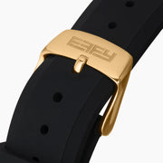 The EARFY 38MM Swiss Made 18K Yellow Gold Automatic Watch features a hexagonal case, black dial with diamond hour markers, black rubber strap, and double row of diamonds outlining the face. Brand name displayed on the dial.