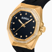 The EARFY 38MM Swiss Made 18K Yellow Gold Automatic Watch features a hexagonal case, black dial with diamond hour markers, black rubber strap, and double row of diamonds outlining the face. Brand name displayed on the dial.