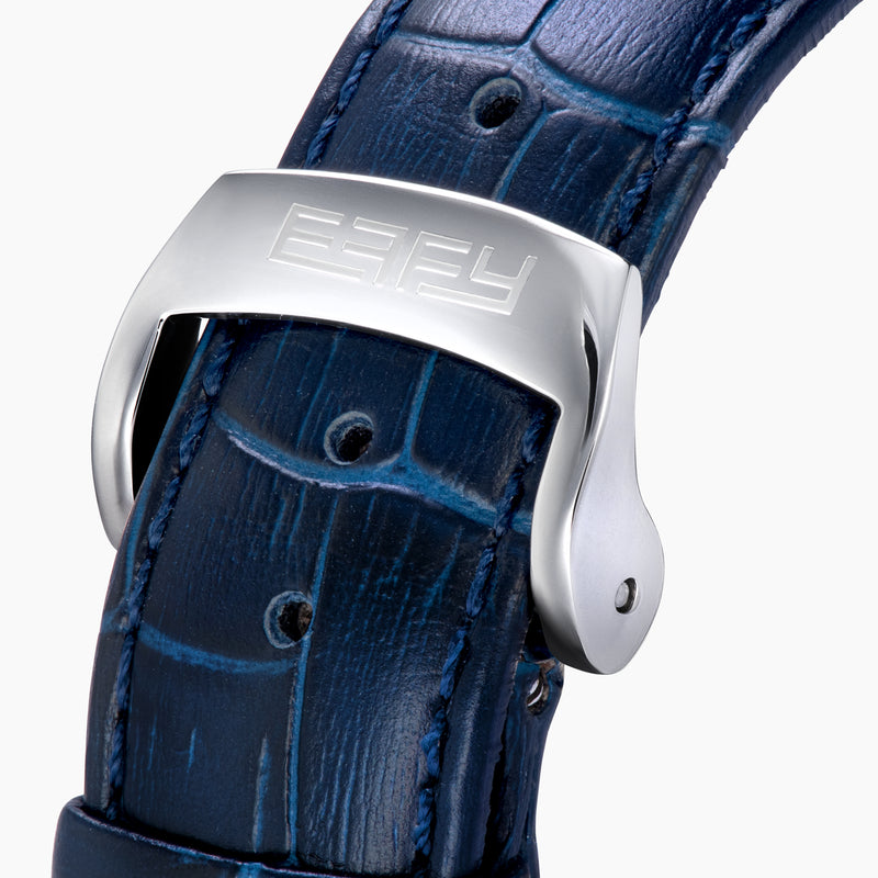 The 41MM Swiss Made Stainless Steel and Leather Automatic Skeleton Watch features a silver case, blue leather strap and bezel, a skeleton dial with visible gears, white hour markers and hands, plus the ERIFY brand name at the top.