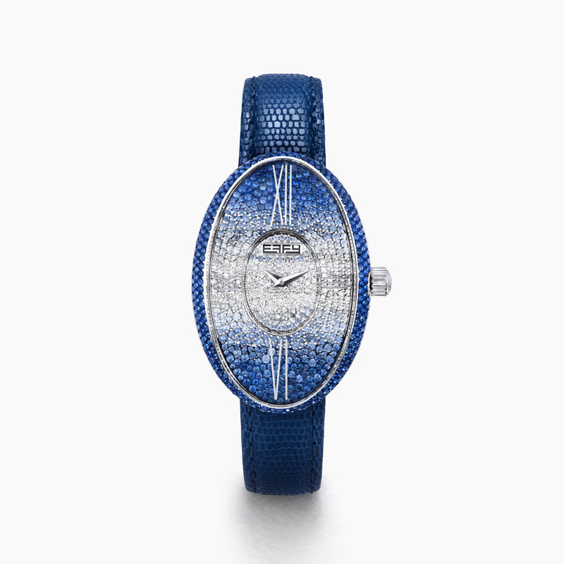 The 28MM Swiss Made Stainless Steel Cocktail Watch features a luxurious oval design with a diamond and blue sapphire-studded face, silver hands, deep blue textured leather strap, and exquisite Swiss craftsmanship.