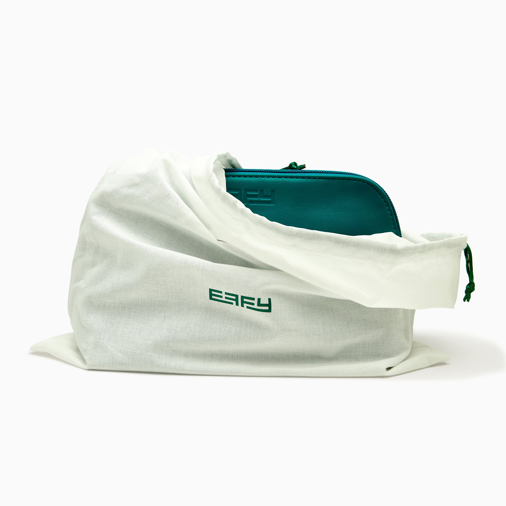 The Effy 2-Piece Travel Pouch set—two teal vegan leather pouches (one large, one small) with embossed logos—is displayed on a white drawstring bag with a matching logo, all set against a plain white background.