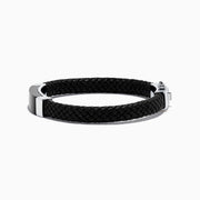 The Mens Sterling Silver and Leather Onyx Bracelet, 12.50 TCW, features a black braided leather band with a rectangular black and silver metal plate and sterling silver clasp, shown on a white background.