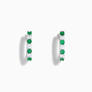 A pair of 14K white gold emerald & diamond hoop earrings, 1.10 TCW, featuring alternating green and clear gemstones set in a silver band, displayed on a white background with soft shadows.