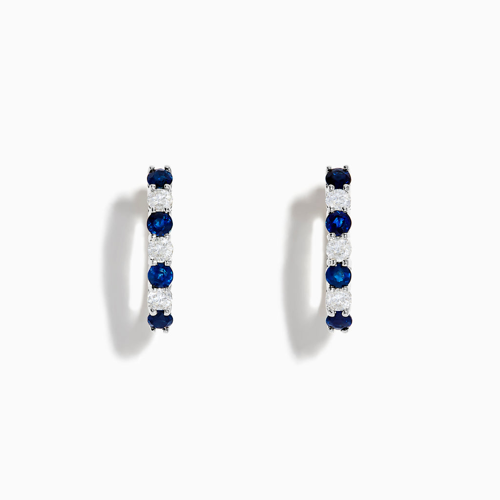 The 14K White Gold Blue Sapphire & Diamond Hoop Earrings, 1.10 TCW, are shown on a plain white background with soft left-side shadows, highlighting alternating sapphire and diamond stones.