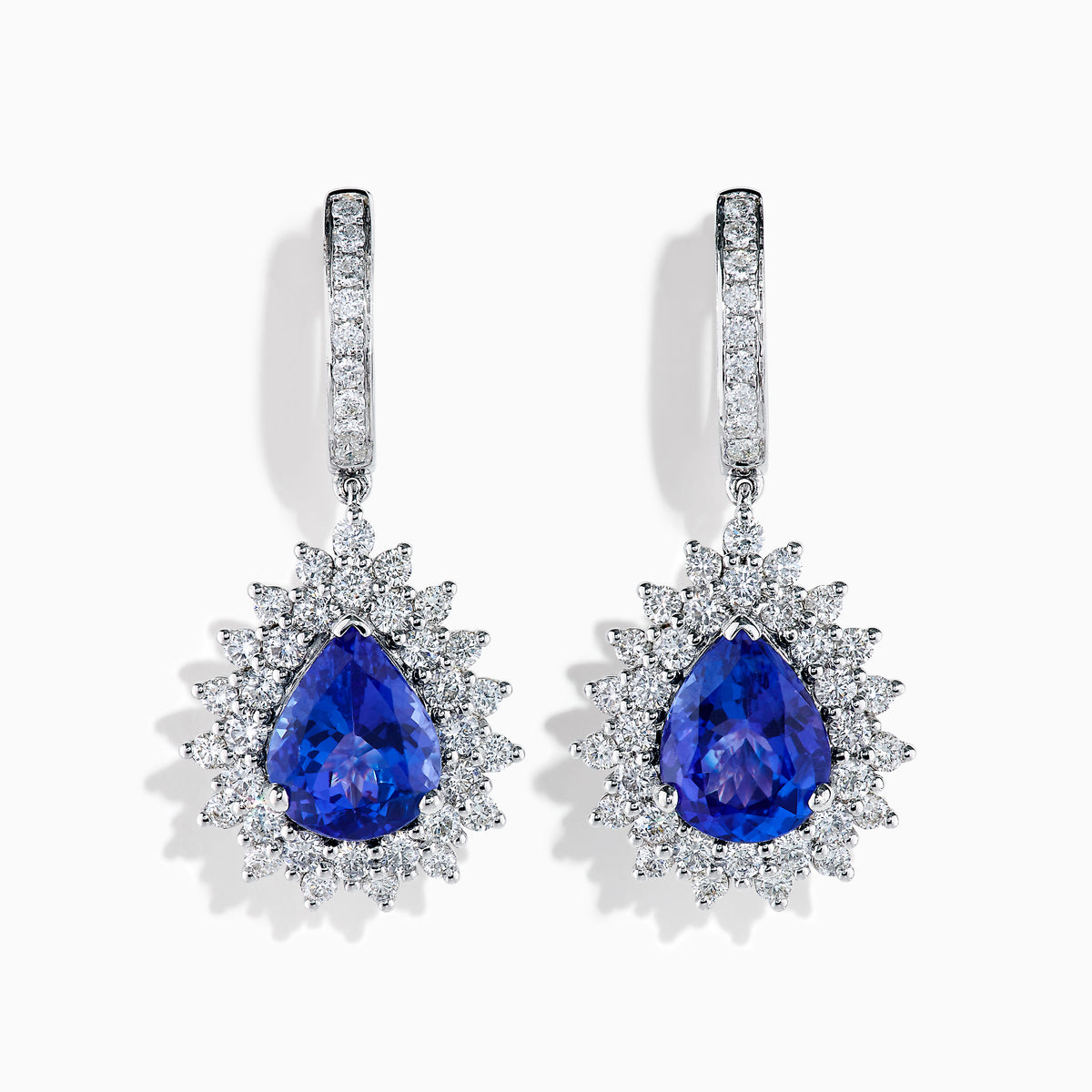 The Effy Hematian 18K White Gold Tanzanite and Diamond Halo Drop Earrings feature large teardrop-shaped blue tanzanites encircled by two rows of sparkling diamonds set in white gold.