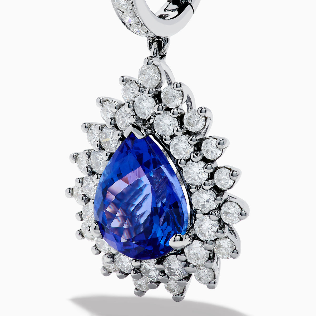 The Effy Hematian 18K White Gold Tanzanite and Diamond Halo Drop Earrings feature large teardrop-shaped blue tanzanites encircled by two rows of sparkling diamonds set in white gold.