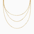 The 14K Yellow Gold Layered Chain Necklace features three delicate chains of different lengths with evenly spaced links, displayed on a white background—a perfect set for achieving effortless elegance.