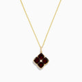 The 14K Yellow Gold Garnet and Diamond Pendant features a four-petal flower-shaped garnet with deep red gemstones outlined in yellow gold and a small clear diamond at the center, shown on a white background.