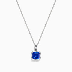 The Nahla Siri 14K Gold Tanzanite and Diamond Pendant features a square blue tanzanite gemstone surrounded by sparkling diamonds, displayed against a white background.
