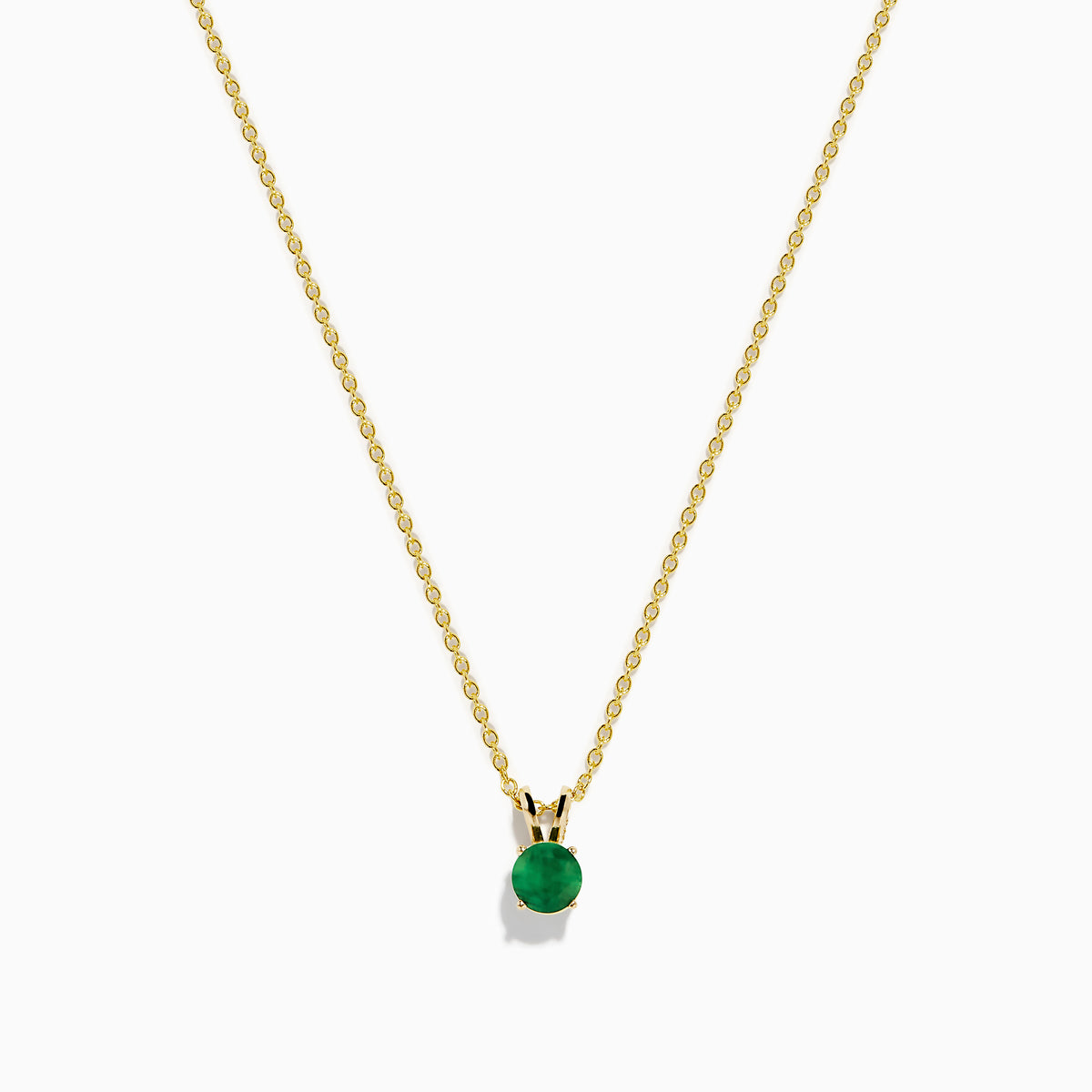 The 14K Yellow Gold Solitaire Round Emerald Pendant (0.48 TCW) features a delicate gold chain and a small round emerald, showcased against a white background.