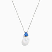 The Nahla 14K White Gold Fresh Water Pearl and Tanzanite Pendant features a round pearl accented with a small, triangular blue tanzanite, all set in white gold and shown against a plain white background.