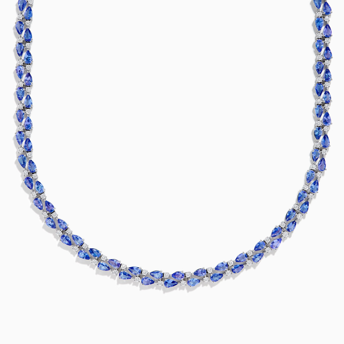 A close-up of the Nahla 14K White Gold Tanzanite and Diamond Necklace, showcasing pear-shaped blue tanzanites and sparkling diamonds set in a symmetrical design against a white background.