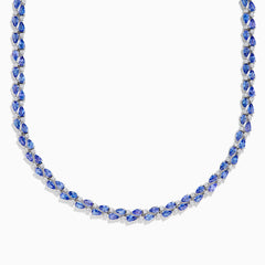 A close-up of the Nahla 14K White Gold Tanzanite and Diamond Necklace, showcasing pear-shaped blue tanzanites and sparkling diamonds set in a symmetrical design against a white background.