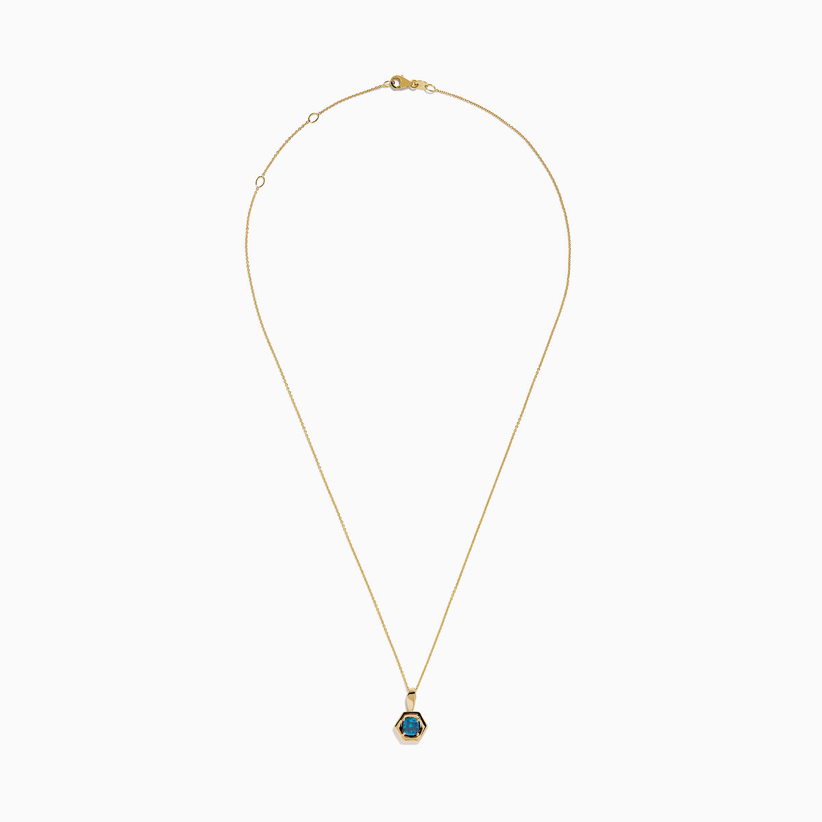The 14K Yellow Gold Blue Diamond Cushion Pendant features a hexagonal pendant with a deep blue gemstone, set on a yellow gold chain and displayed against a white background.