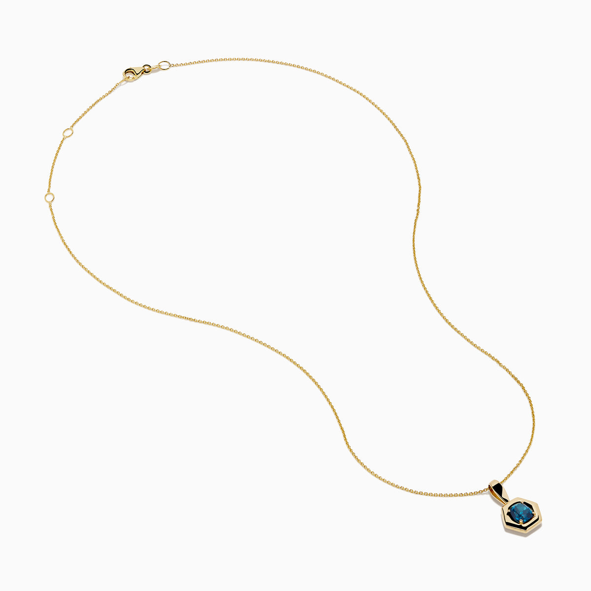 The 14K Yellow Gold Blue Diamond Cushion Pendant features a hexagonal pendant with a deep blue gemstone, set on a yellow gold chain and displayed against a white background.